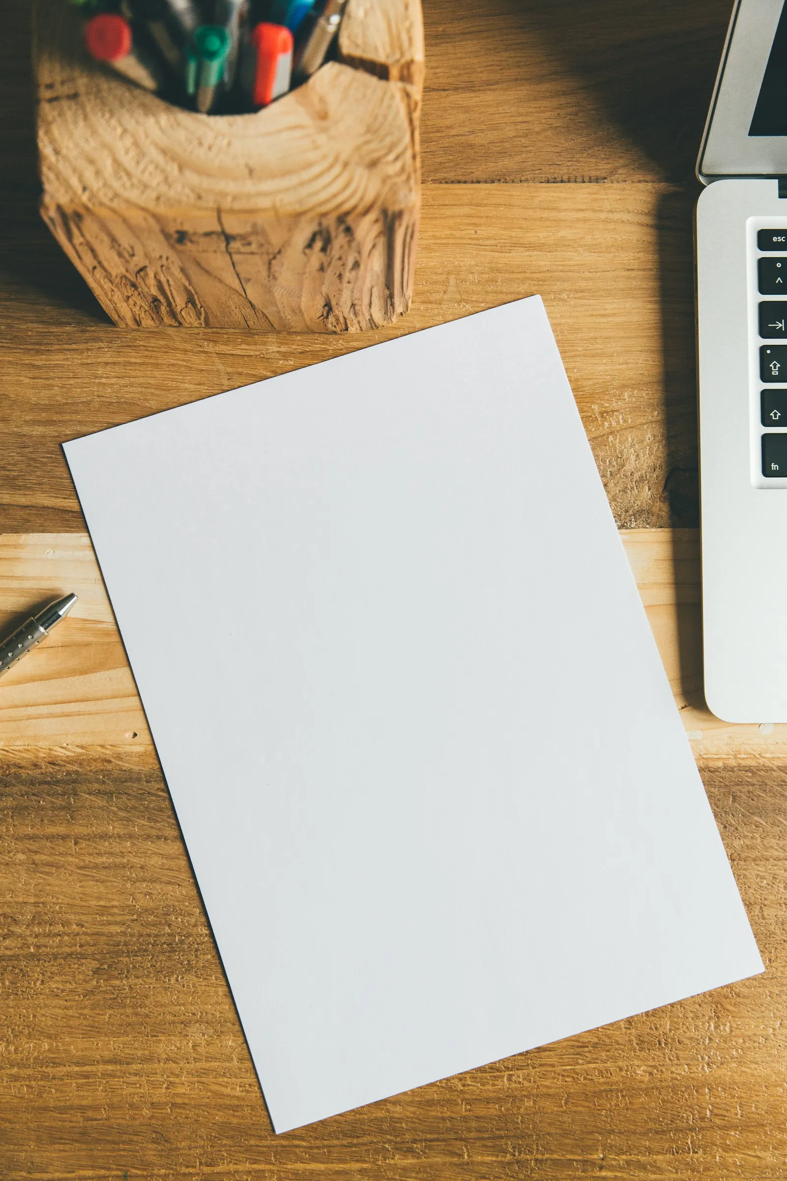 A blank sheet of paper and a pen on a desk